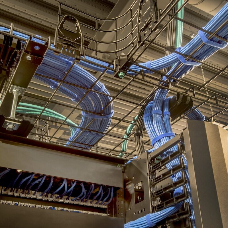 Overhead Cable Trays with Cat 5 Wires Cable trays in a data center with cat 5 and optic fiber cables.